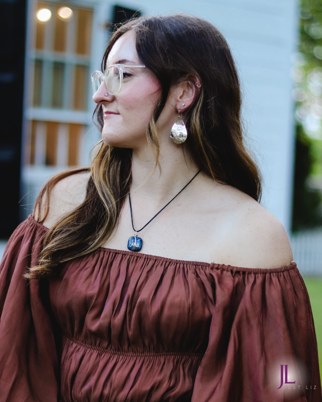 Woman posing and wearing a silver wire wrapped square shaped lapis stone necklace
