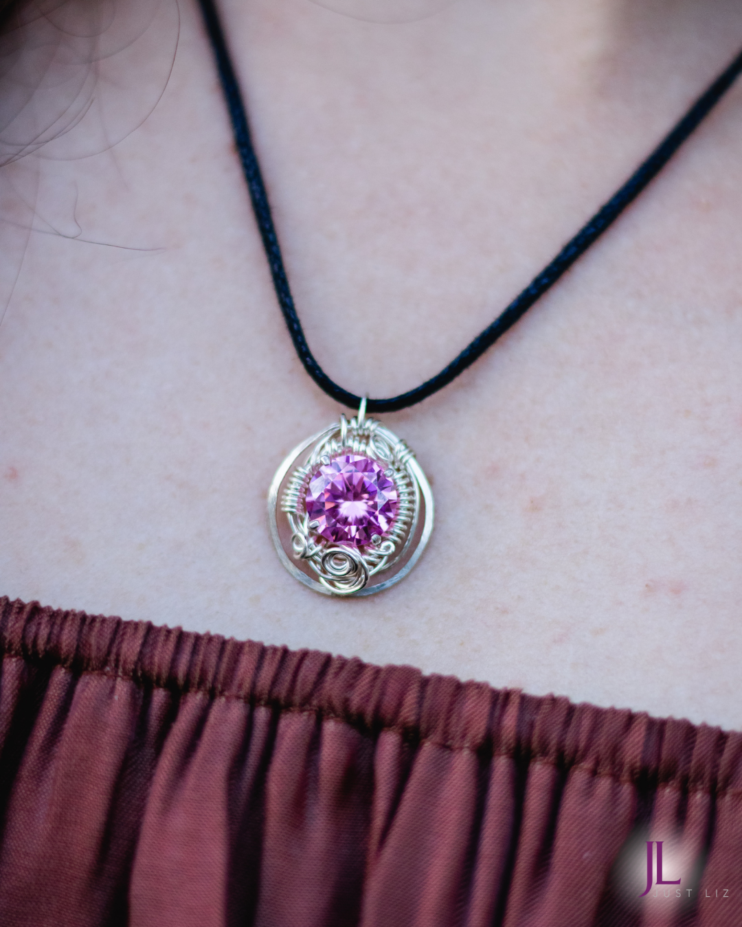 Woman wearing a round silver wire wrapped pink tourmaline necklace