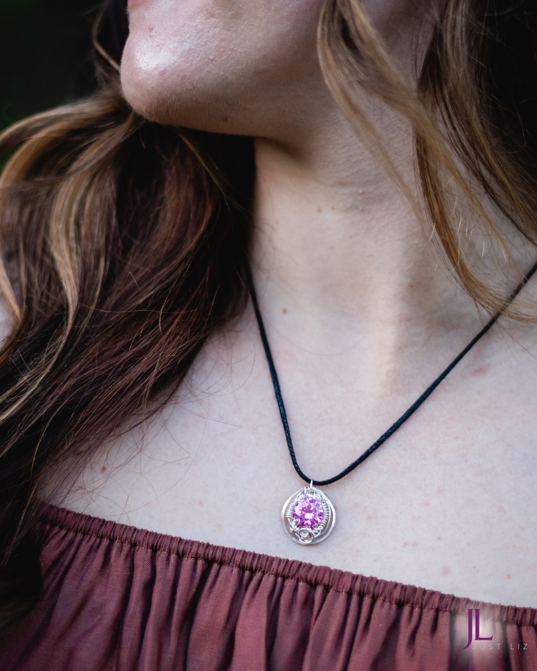 Woman wearing a round silver wire wrapped pink tourmaline necklace