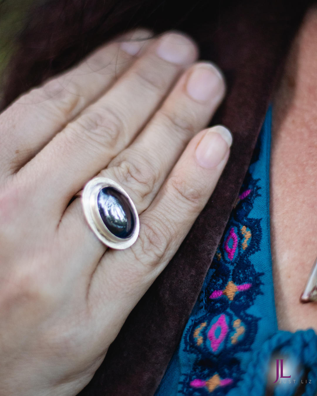 Woman wearing a big oval shaped hematite stone ring