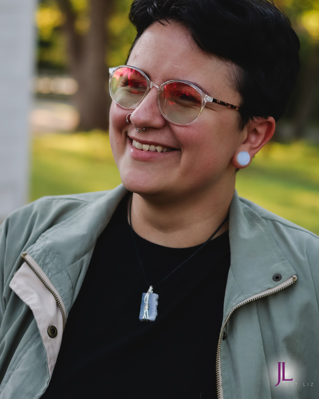 Woman smiling and wearing a blue and green druzy stone necklace