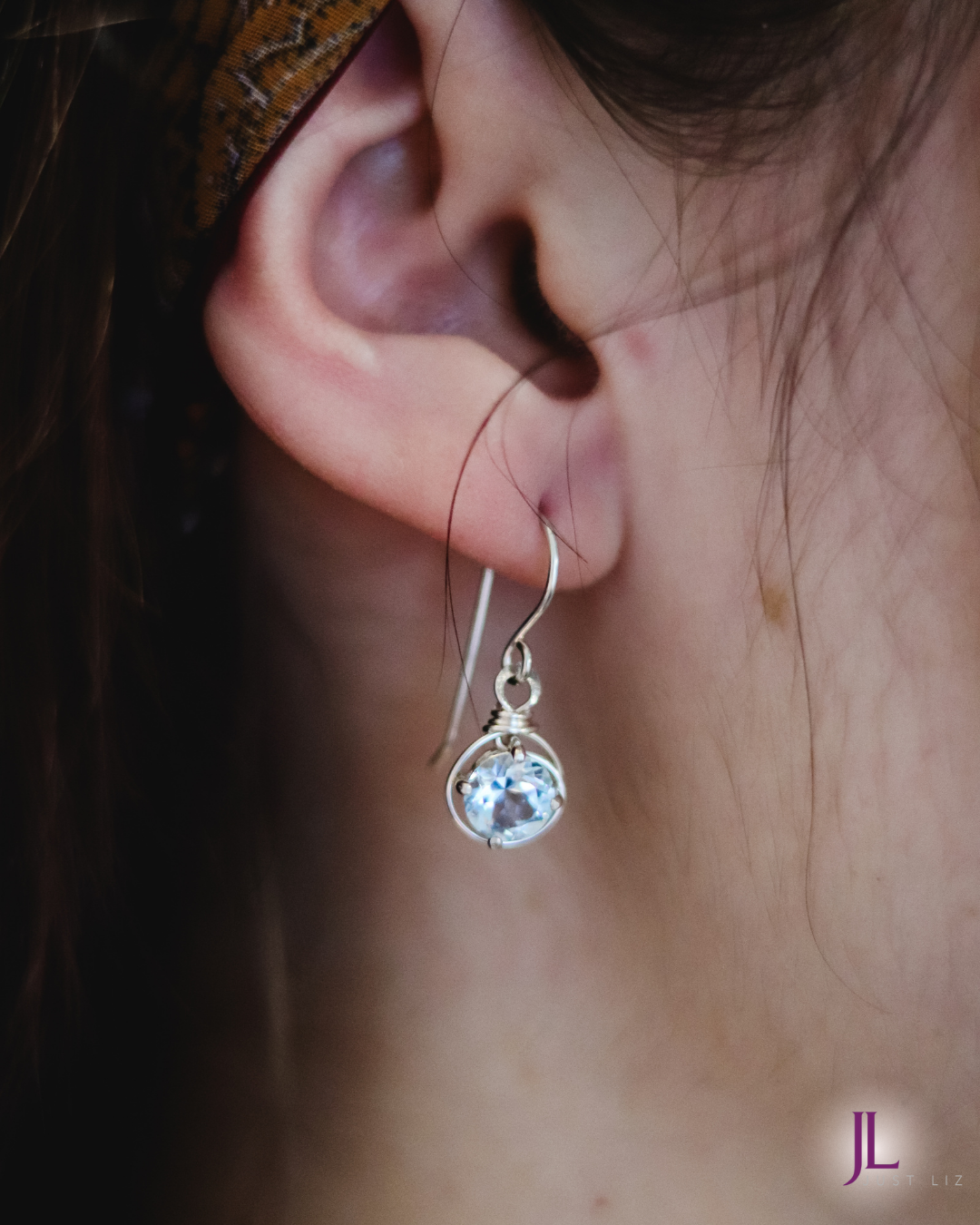 Woman wearing blue topaz earrings