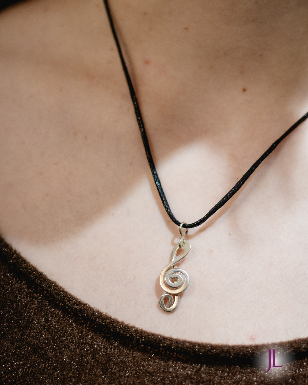 Woman wearing a silver treble clef necklace