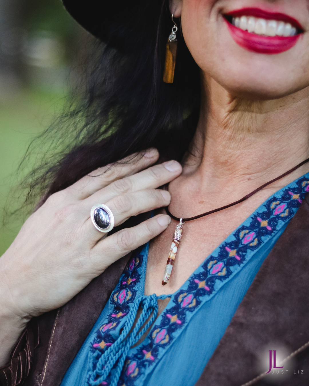 Woman smiling and wearing a thin and long jasper stone necklace