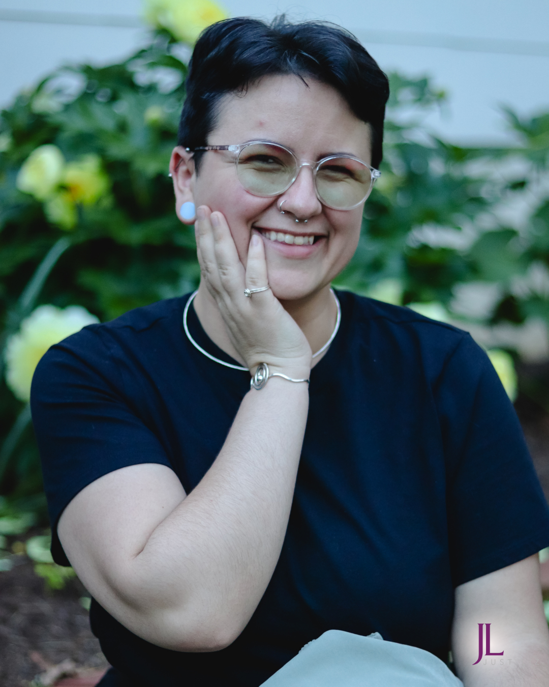 Woman smiling and wearing a silver music note bracelet and a small spiral silver ring