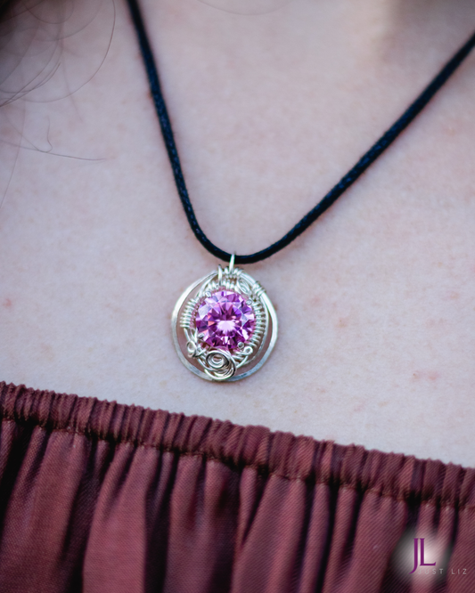 Woman wearing a round silver wire wrapped pink tourmaline necklace