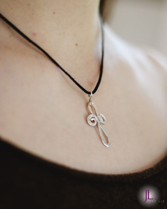 Woman wearing a swirly silver cross necklace