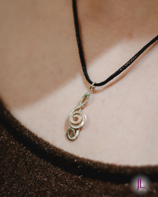 Woman wearing a silver treble clef necklace