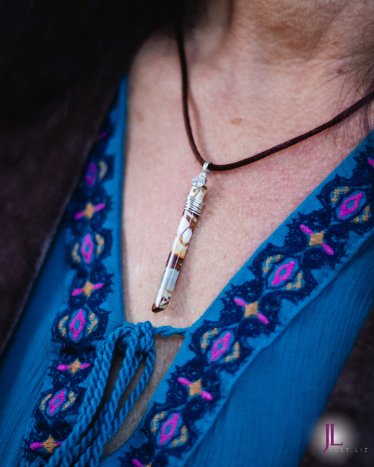 Woman wearing a thin and long jasper stone necklace